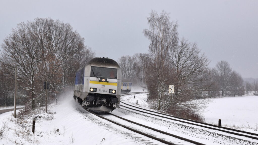 Der Zug RE6 fährt durch eine Schneelandschaft