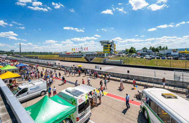 Viele Leute und Zelte stehen in der Boxengasse des Sachsenrings.