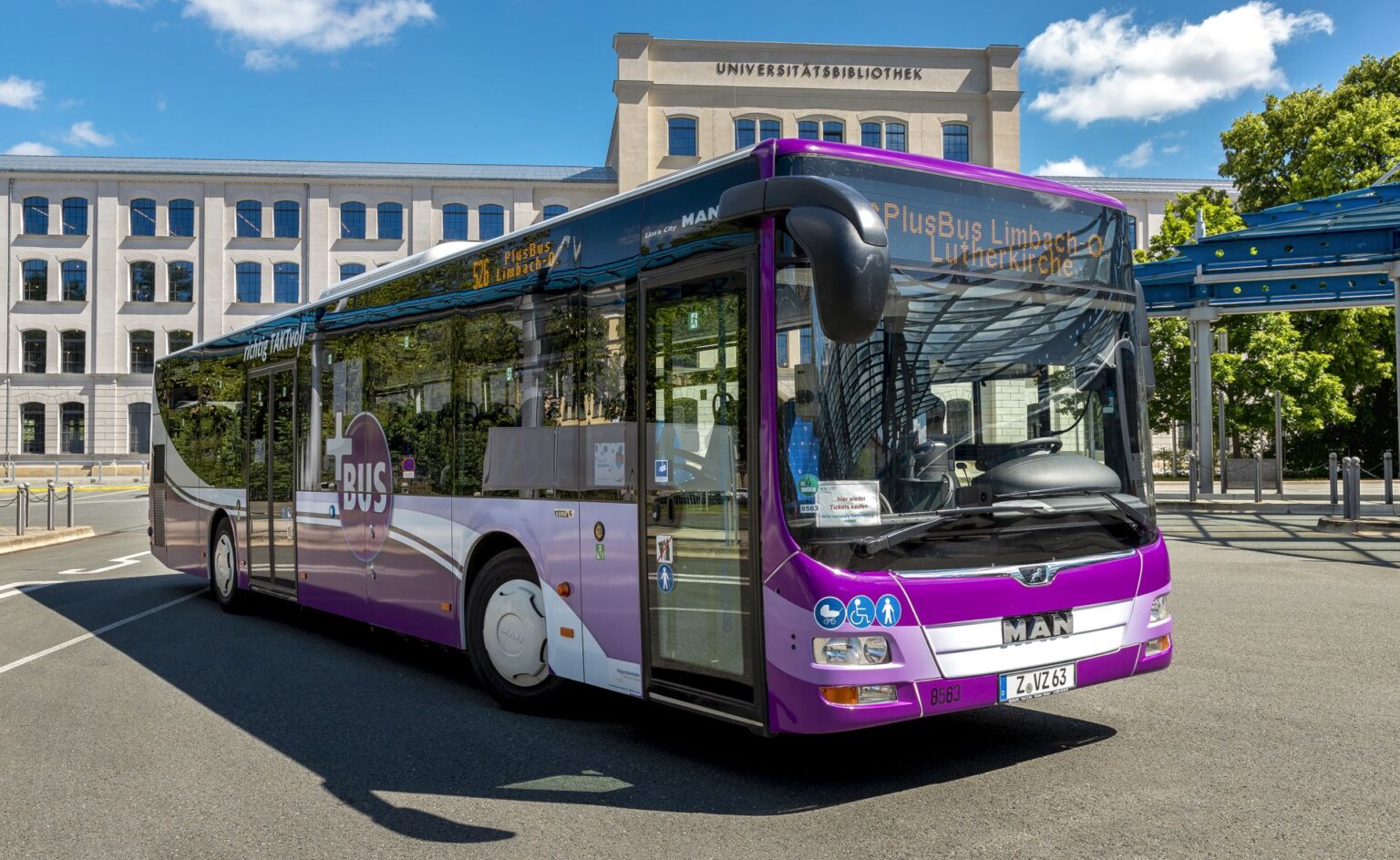 Ein lilafarbener Plusbus steht vor der Universitätsbilbiothek.