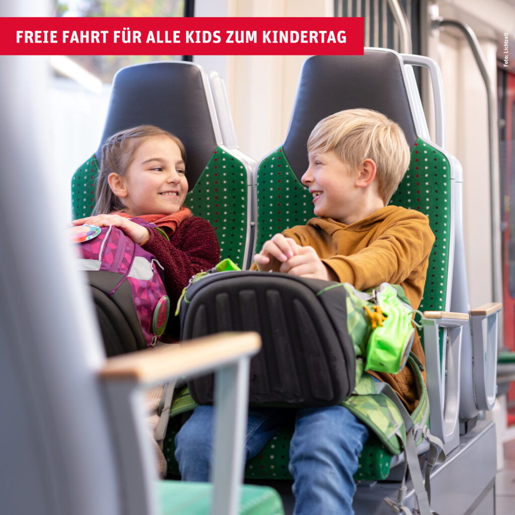 Zwei fröhliche Kinder sitzen in einem Citylink