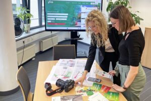 Zwei VMS-MItarbeiterinnen betrachten Printprodukte