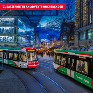 Zwei Chemnitz-Bahnen fahren vor Kulisse des Chemnitzer Weihnachtsmarktes