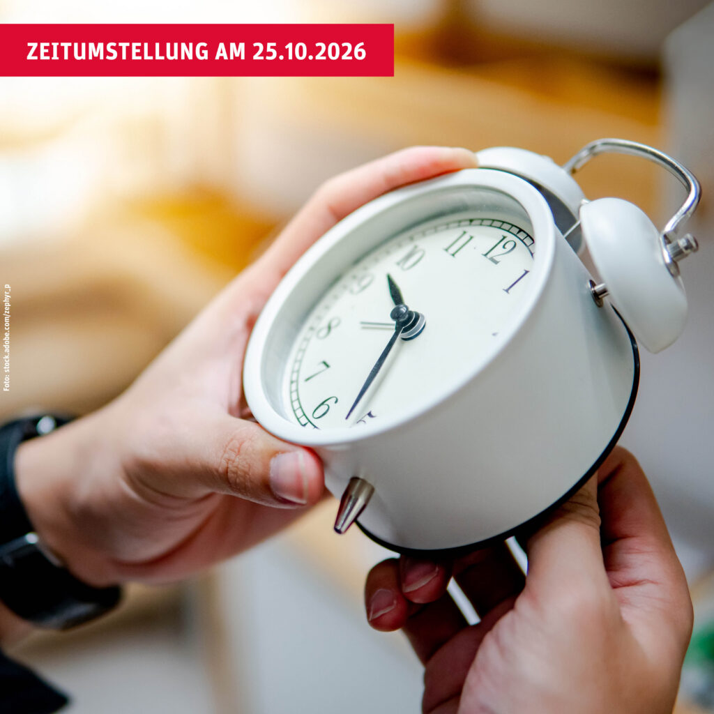 Hände ändern Uhrzeit an weißem Wecker