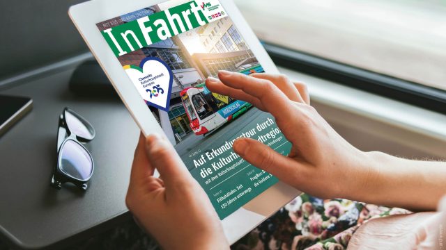 Frau liest im Zug InFahrt-Kundenmagazin auf dem Tablet