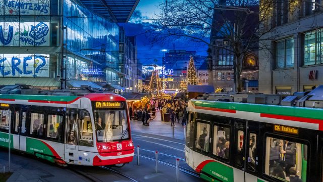 Zwei Chemnitz-Bahnen fahren vor Kulisse des Chemnitzer Weihnachtsmarktes